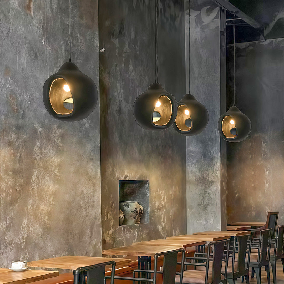 Nordic Wabi Sabi Pendant Lights in a rustic café setting, casting warm ambient glow on textured concrete wall.