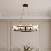 Elegant wagon wheel style modern luxury chandeliers featuring a black and gold metal frame with cylindrical glass shades in a sophisticated dining room.