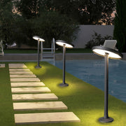 Tall modern path lights outdoor lining a walkway beside a building with soft warm lighting.