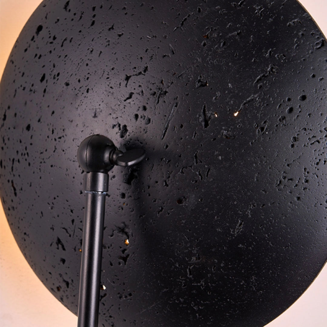 Close-up of a wall adjustable light showing the black textured shade and movable ball joint.