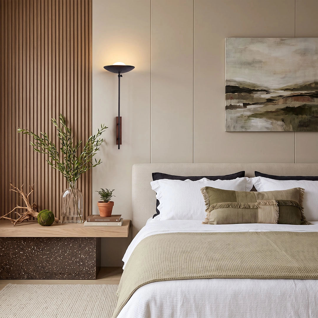 Wall adjustable light providing focused bedside illumination in a modern bedroom with natural wood accents.