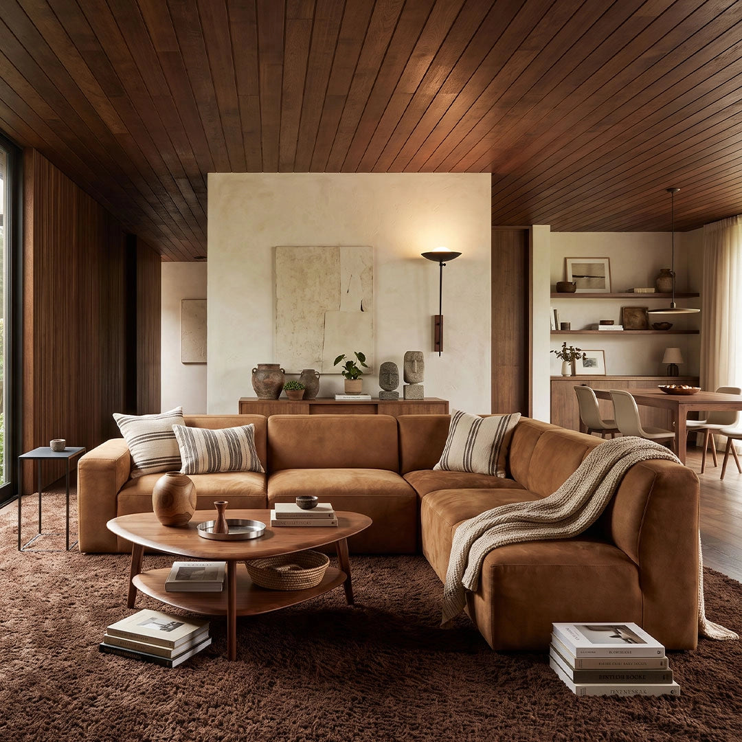 Wall adjustable light adding warm accent lighting above a sectional sofa in a wood-paneled living room.