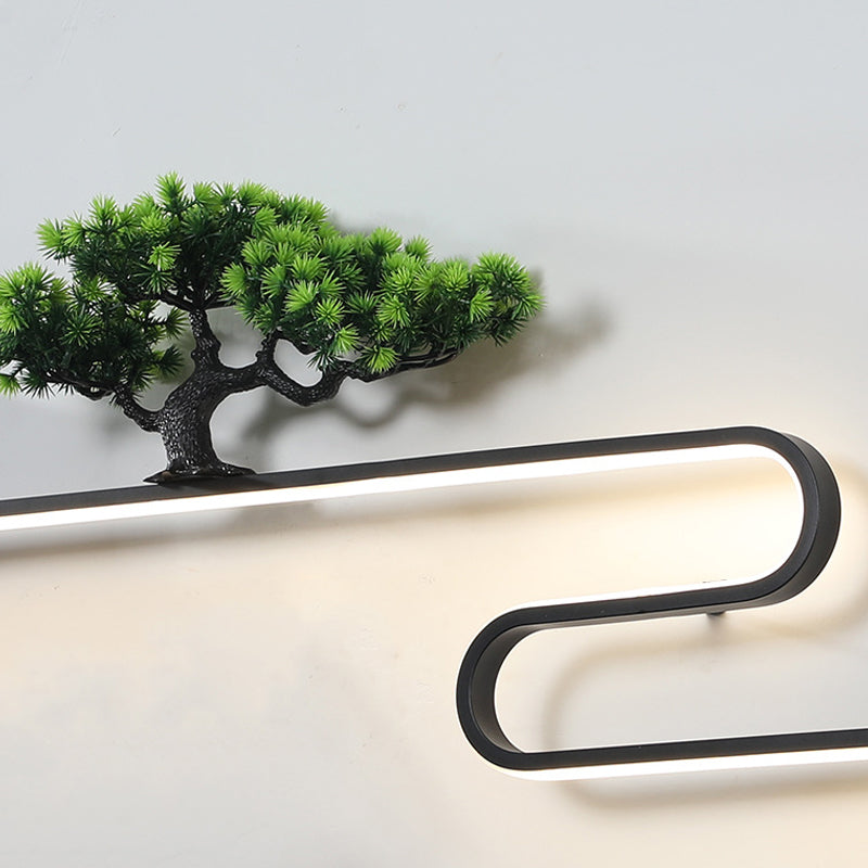 Wall art with light featuring a mountain and tree design, installed on a white wall.