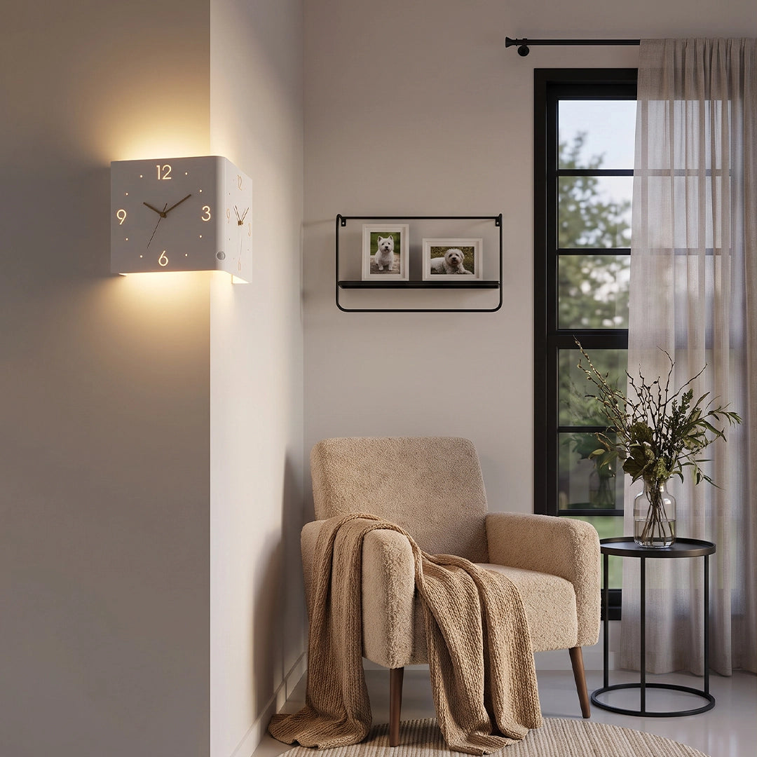 Wall clock lamp mounted above a chair in a reading corner with soft drapery and warm lighting.