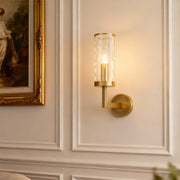 Wall glass light illuminating elegant hallway with paneled walls and gold-framed artwork