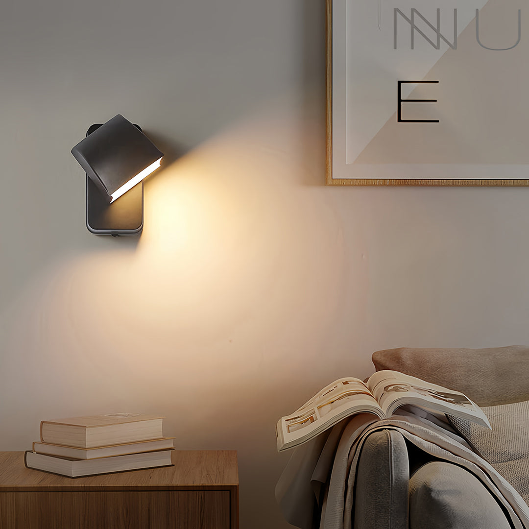 Wall industrial lights mounted beside door on gray wall casting warm glow at dusk