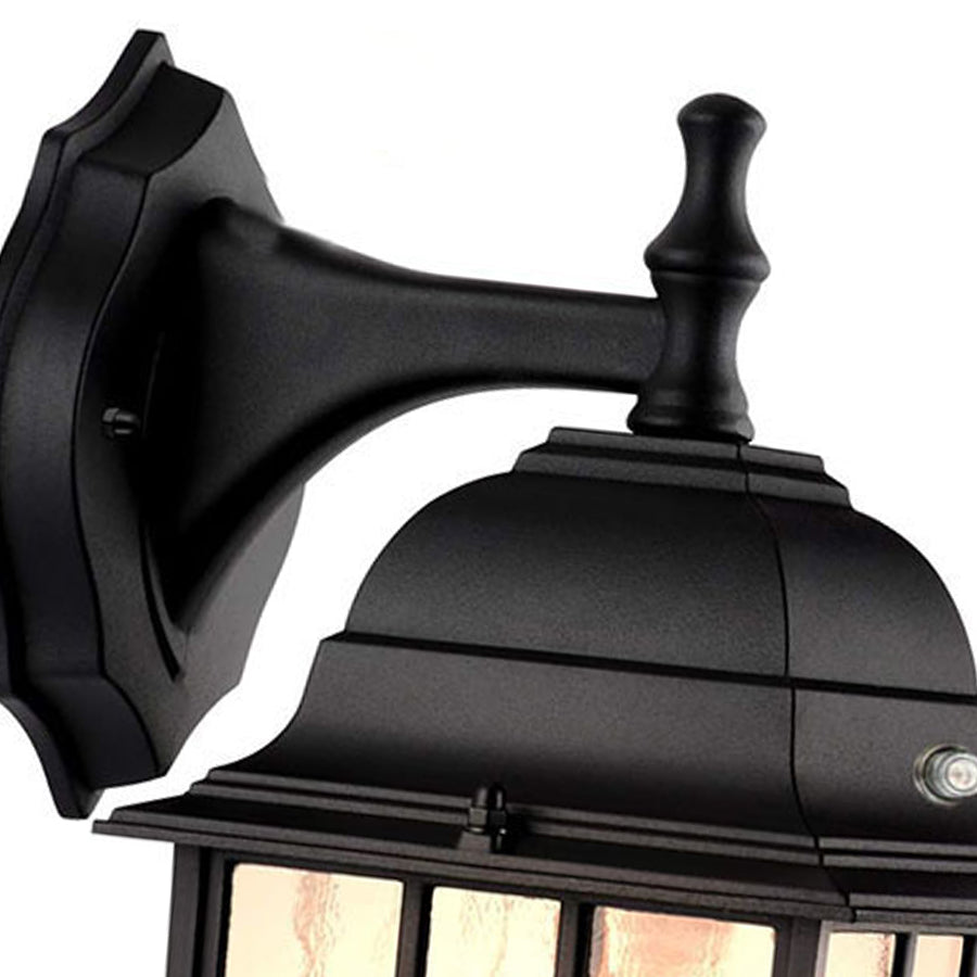 Close-up detail of black outdoor wall lantern showing mounting bracket and traditional cage design