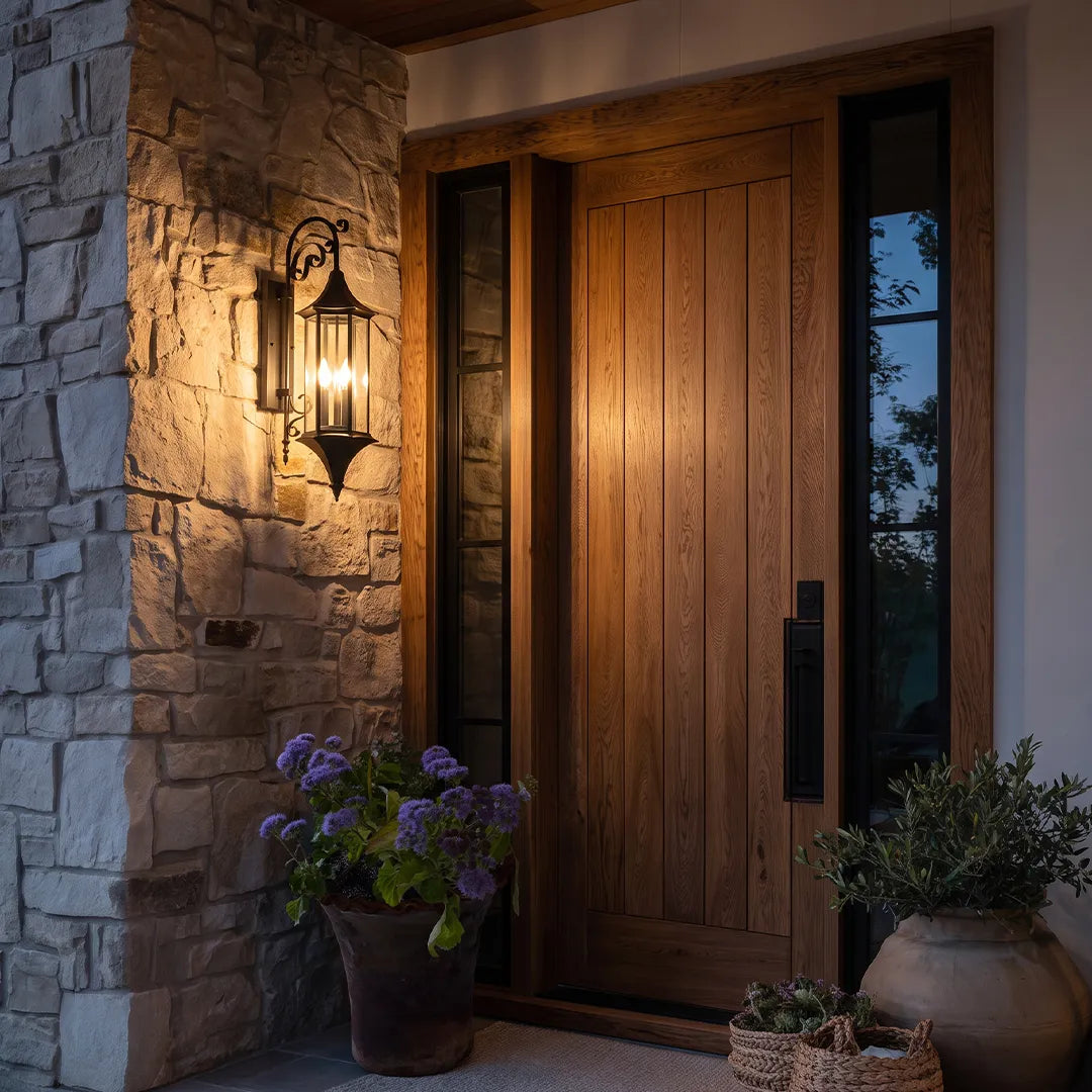 Wall lanterns outdoor lighting installed beside a modern wooden front door on a textured stone exterior.