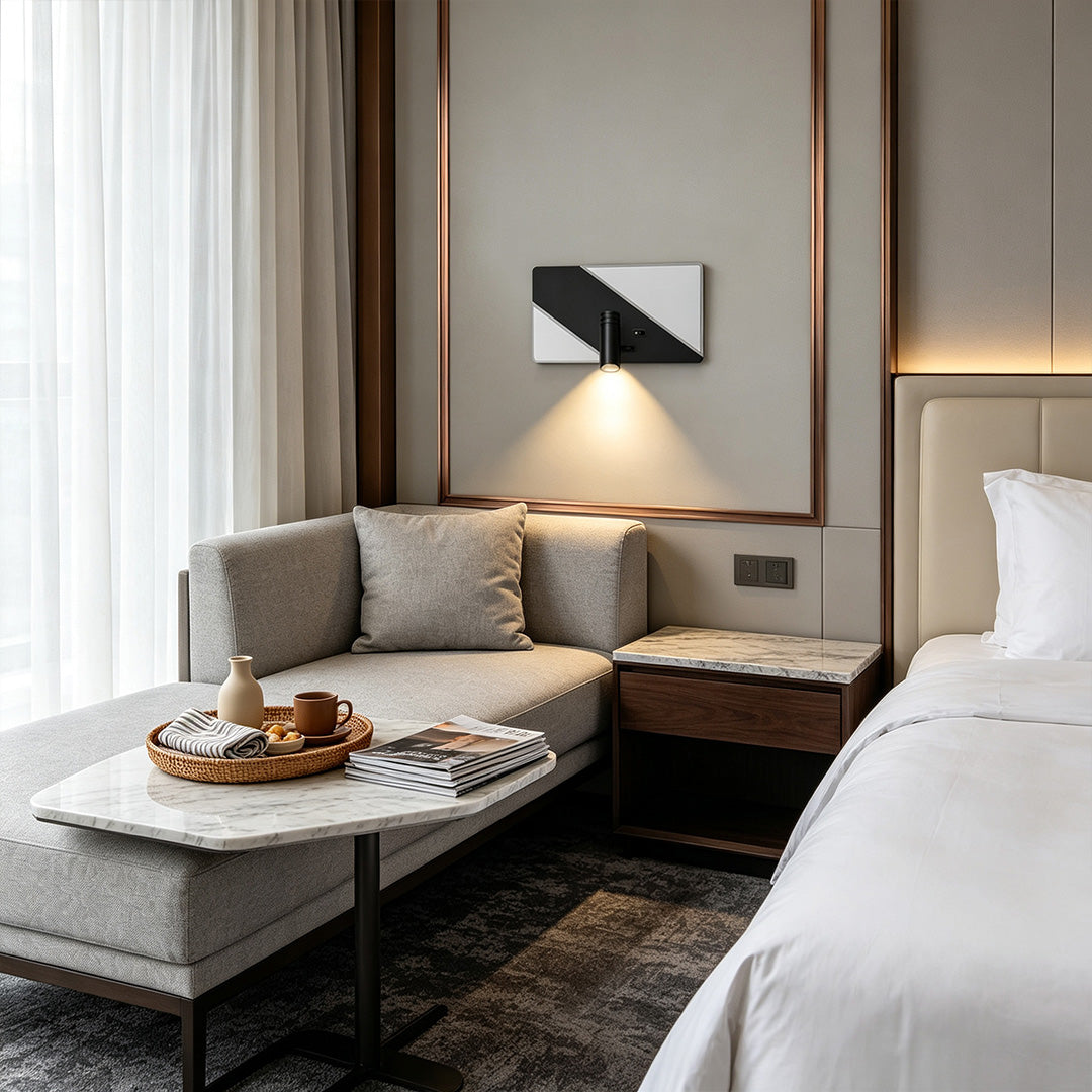 Contemporary wall light with reading light beside hotel bed featuring adjustable spotlight and warm glow.