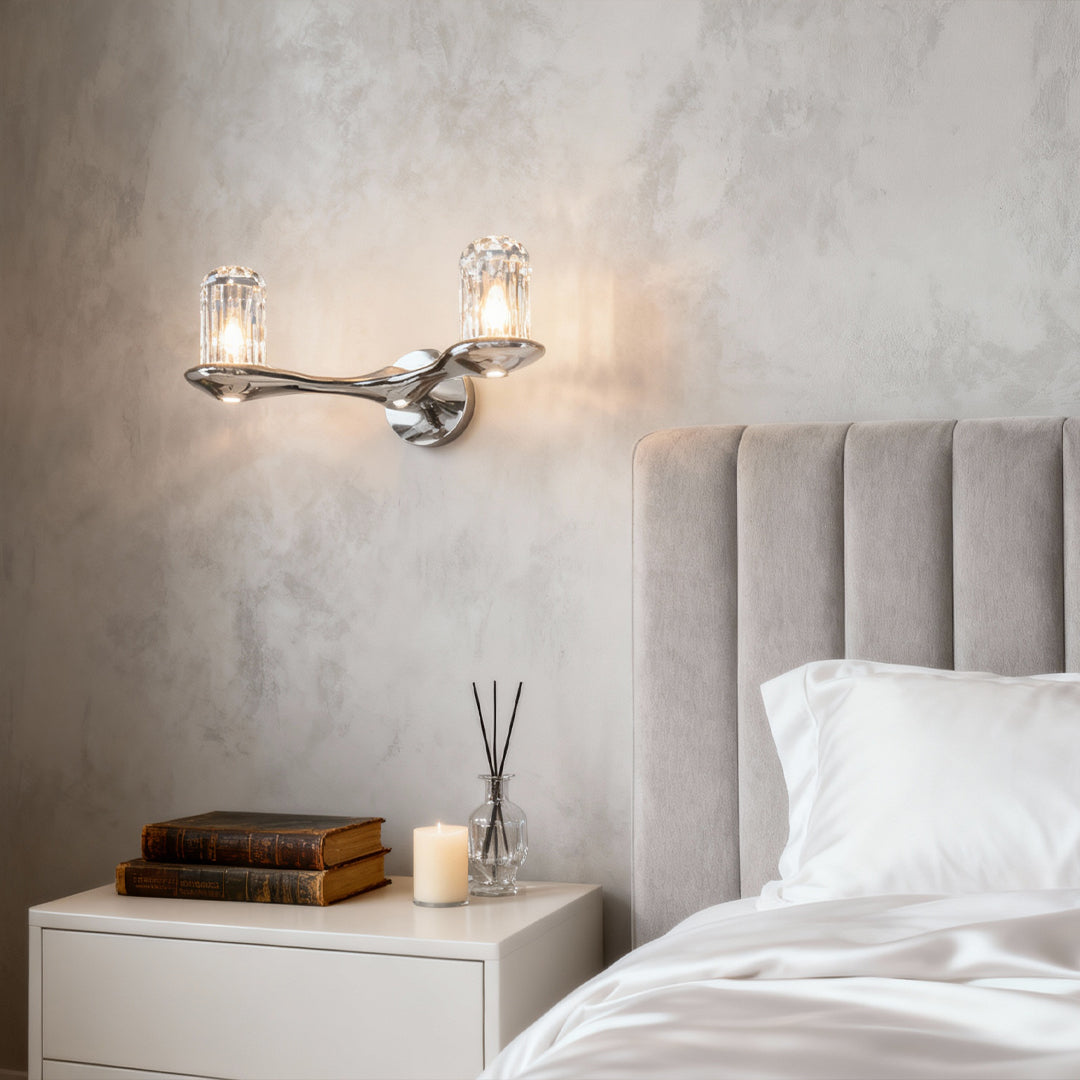 Wall lights with crystals serving as bedside lighting in serene bedroom with tufted headboard and minimal styling