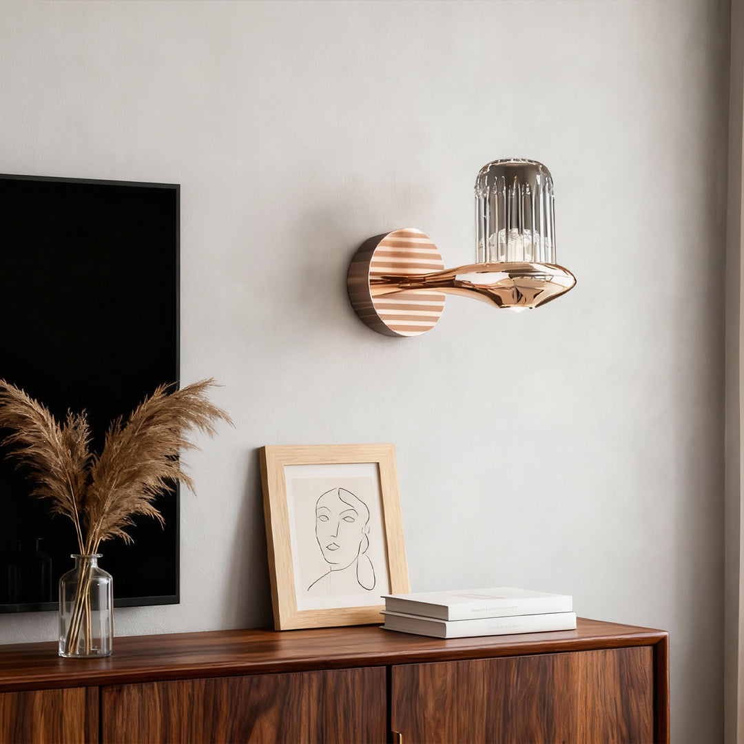 Wall lights with crystals providing accent lighting on neutral wall above wooden cabinet with minimalist decor