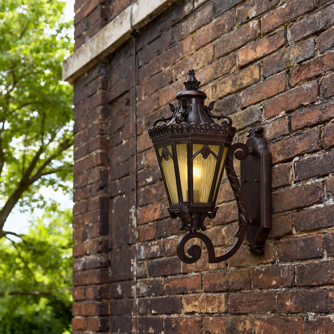 Wall mount light outdoor brightening rustic brick facade with ornate scroll bracket in daylight