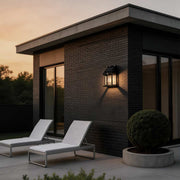 Wall mount solar lantern installed on a modern house exterior with warm light at dusk.