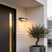 Wall mount solar lights outdoor with a modern rectangular design, illuminating a house entrance.