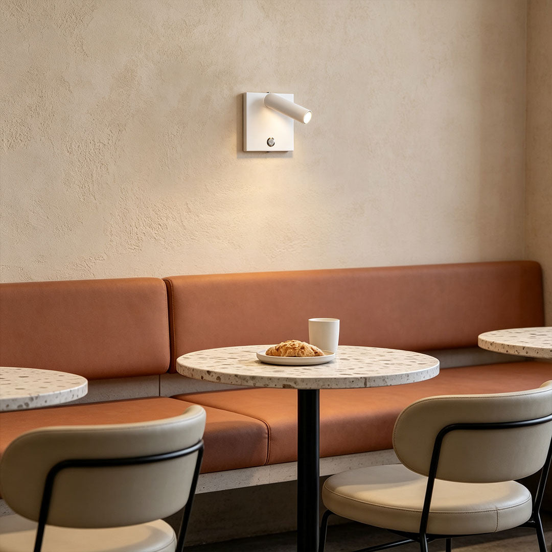 Contemporary wall mountable reading light illuminating cafe seating area with adjustable white spotlight.