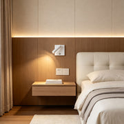 Modern wall mountable reading light installed beside bed with warm focused lighting and wood panel accents.
