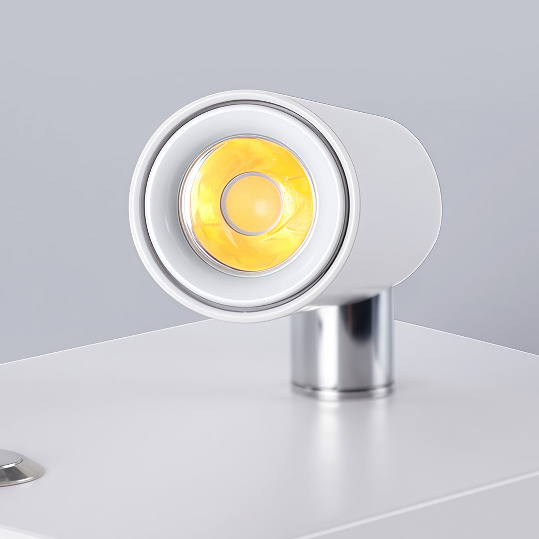 Close-up detail of white wall mountable reading light with cylindrical LED spotlight and metal base.