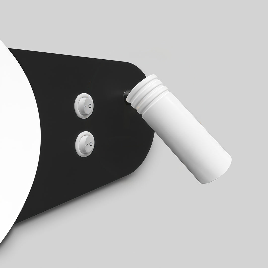 Close-up detail of wall mounted bedside reading light with black backplate and white spotlight design.