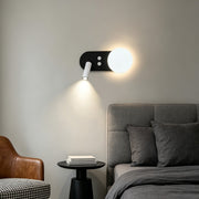 Modern wall mounted bedside reading light with adjustable spotlight and glowing orb in cozy living room.