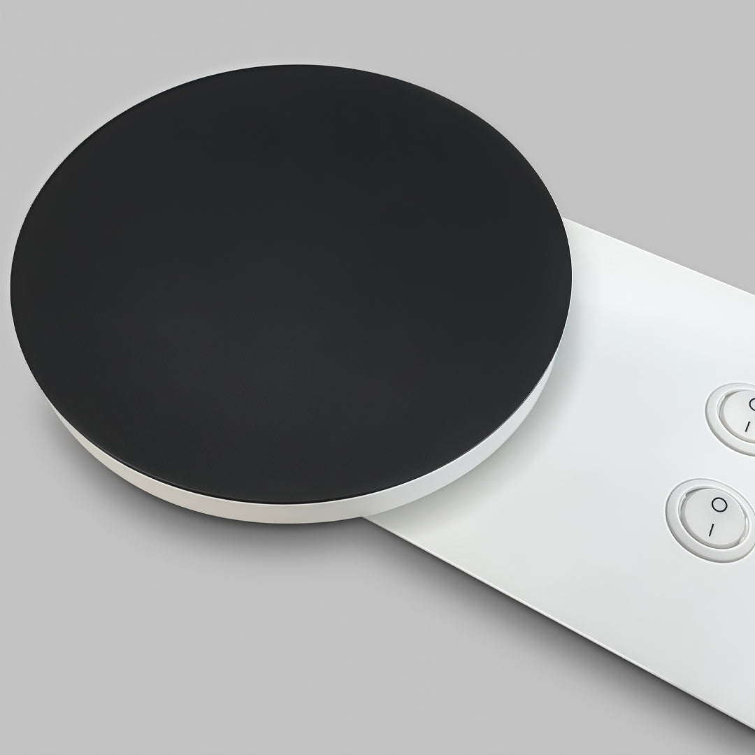 Round black wall mounted bedside reading light with adjustable white spotlight and modern minimalist design.