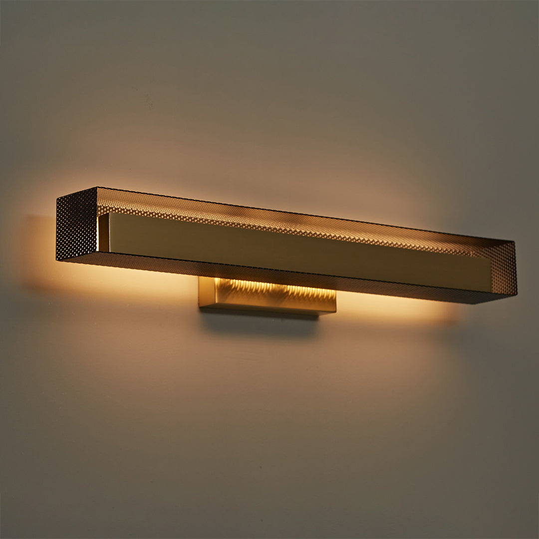 Wall-mounted brass wall picture lights casting warm glow on beige wall.