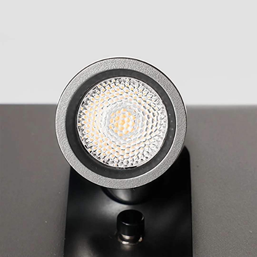 Close-up of wall mounted LED reading light showing the circular LED lens and textured reflector.