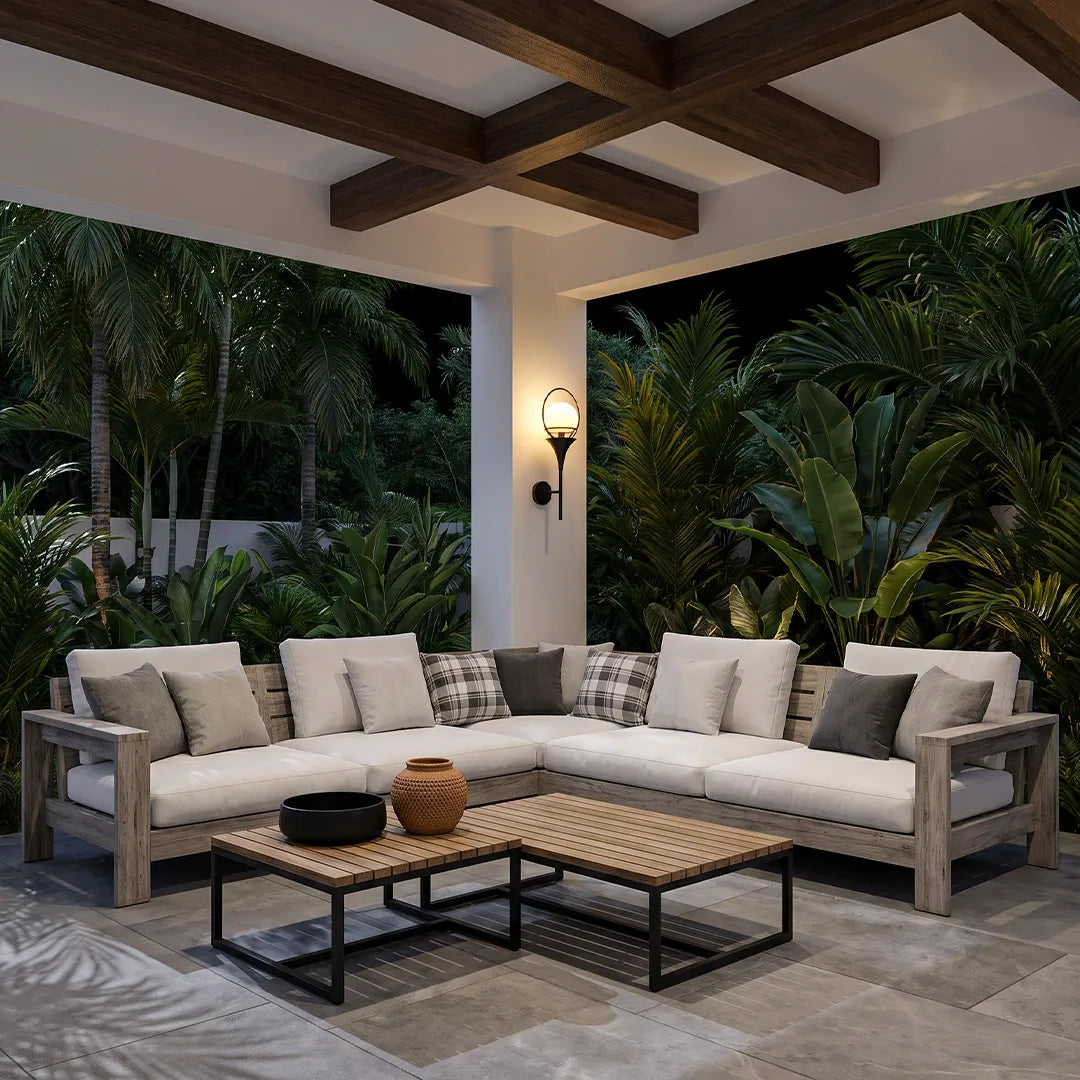 Wall mounted outdoor lighting adding warm illumination to a covered patio lounge with sectional seating.