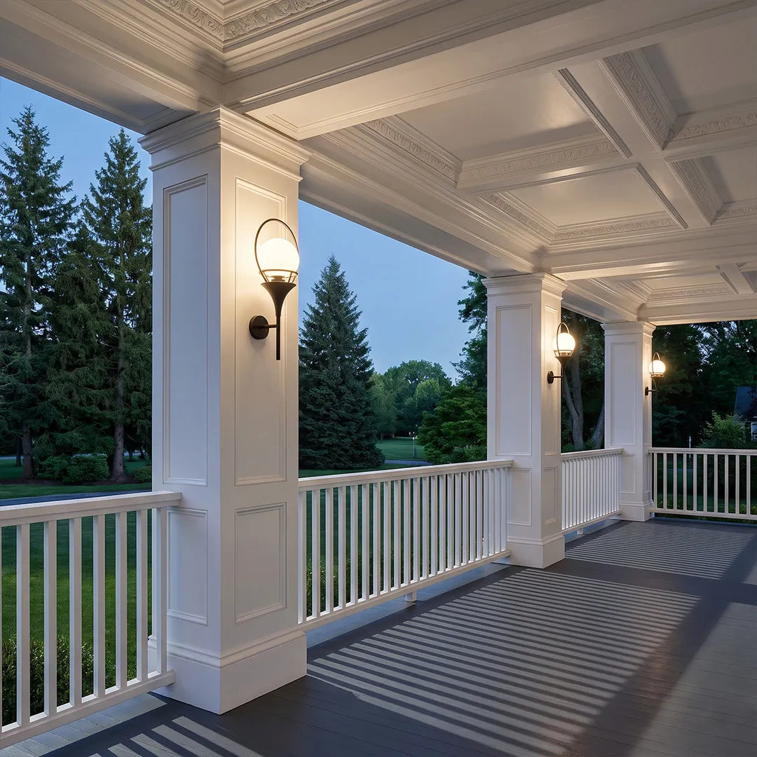 Wall mounted outdoor lighting installed along a spacious covered porch with white columns and railings.