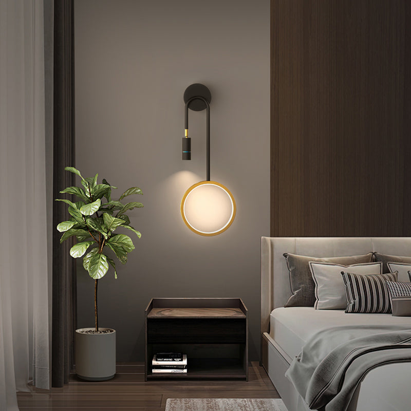 Wall pendant light casting warm illumination in a cozy bedroom with wooden furniture.