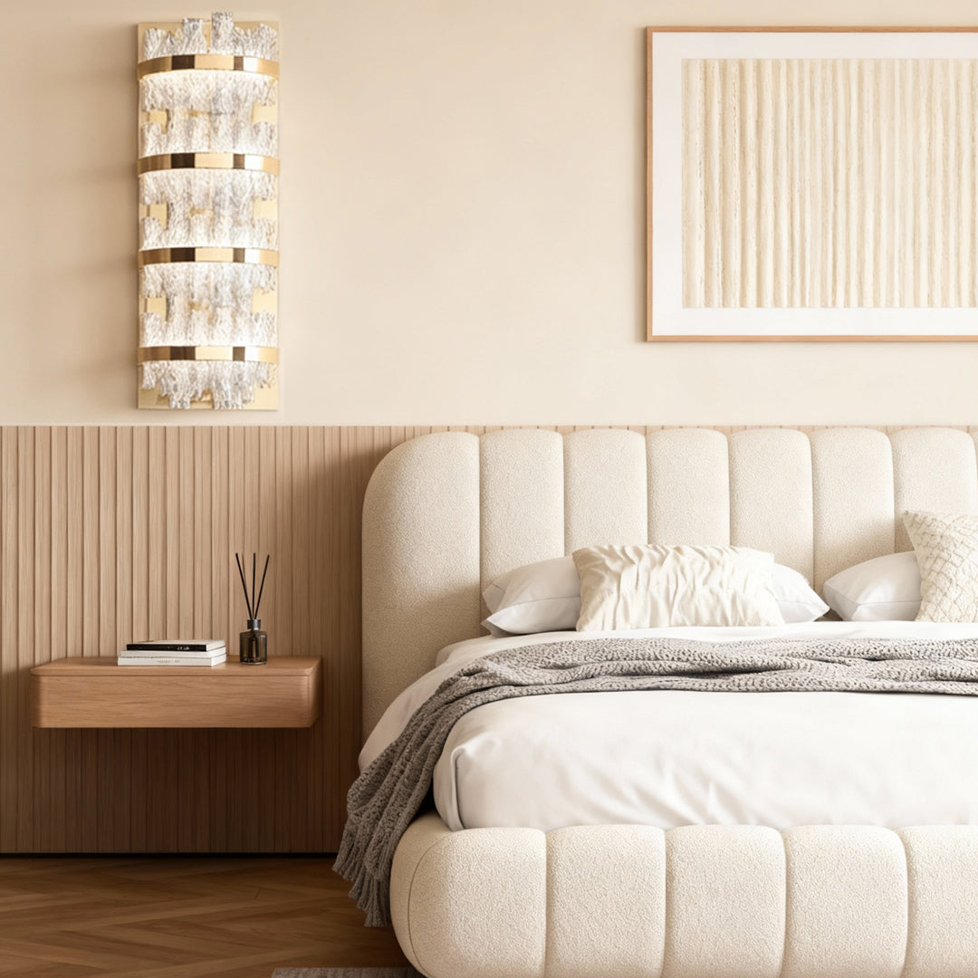Wall sconce glass flanking upholstered bed in elegant bedroom with ribbed wood paneling and neutral color scheme