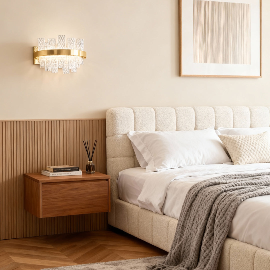 Wall sconce glass creating warm illumination above mid-century modern nightstand in neutral-toned bedroom with upholstered headboard