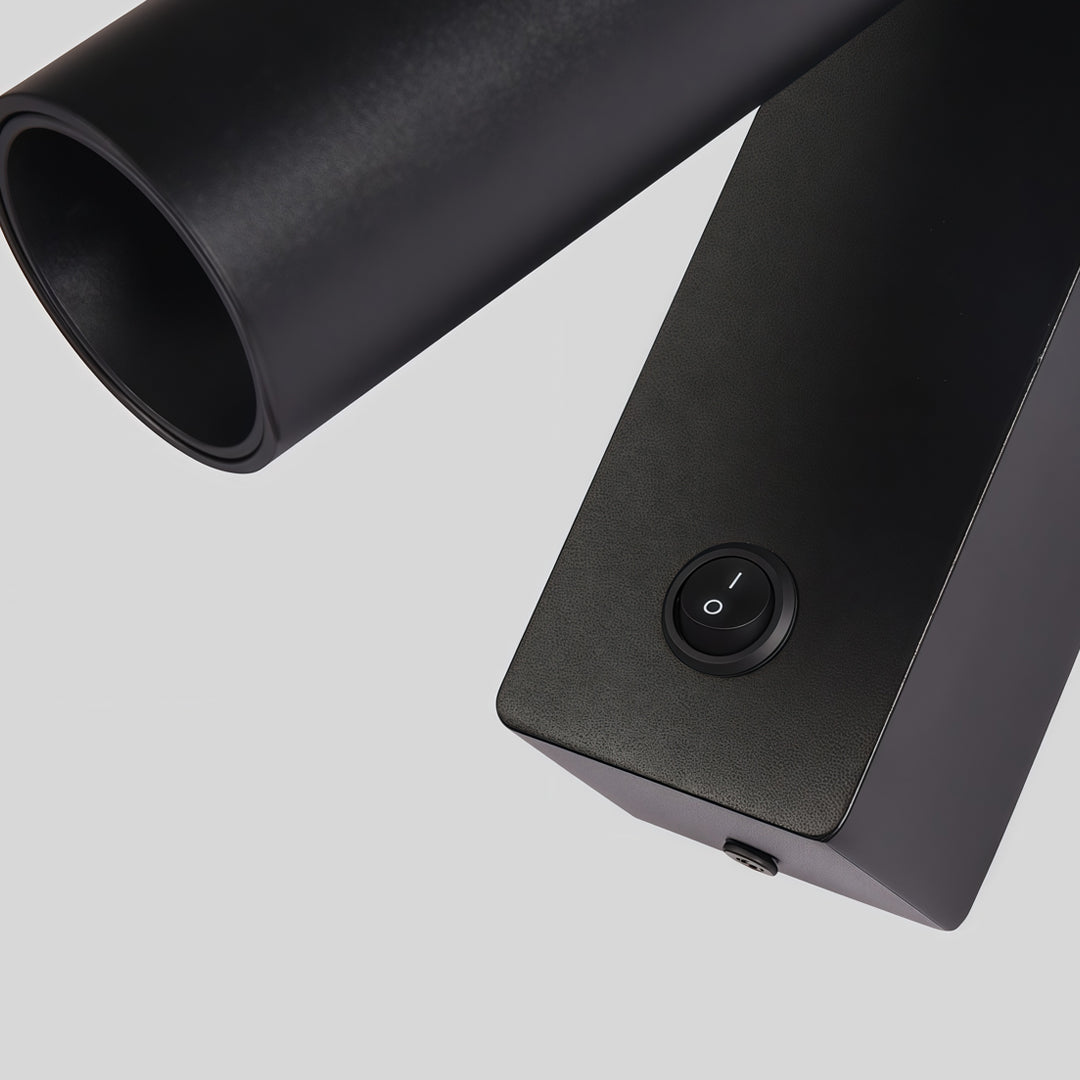Detailed view of wall sconce reading light featuring matte black body and integrated push button switch.