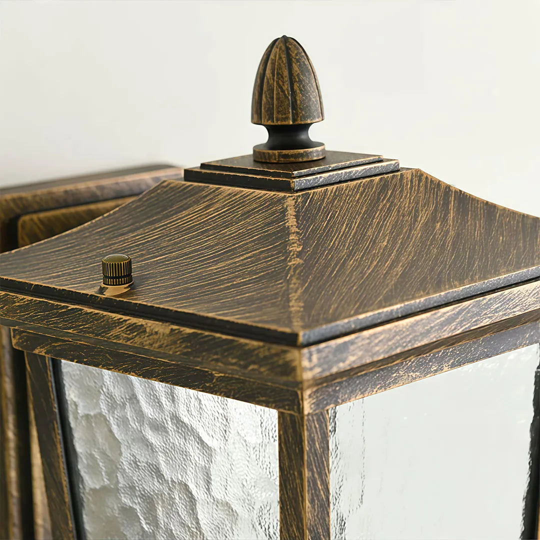 Wall vintage lights close-up showing the weathered bronze top and decorative lantern finial.