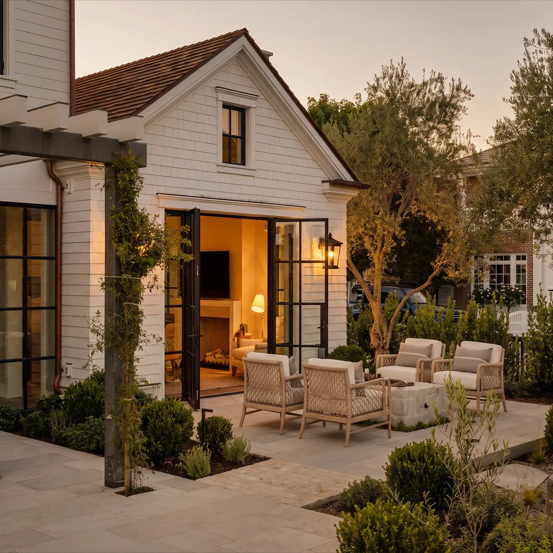 Wall vintage lights mounted beside French doors with flowers for a welcoming exterior entrance.