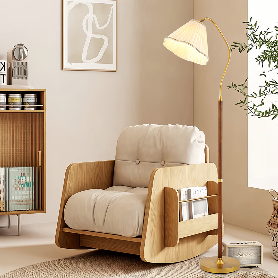 Walnut floor lamp illuminating cozy reading corner with wooden furniture and plants