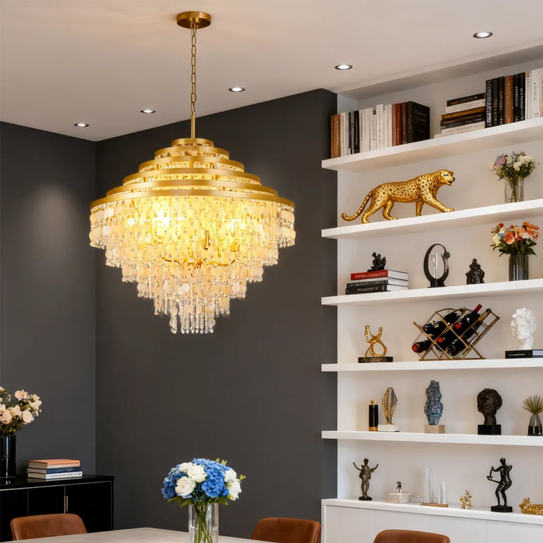 Elegant gold-tiered crystal chandelier with hanging shells in a modern interior