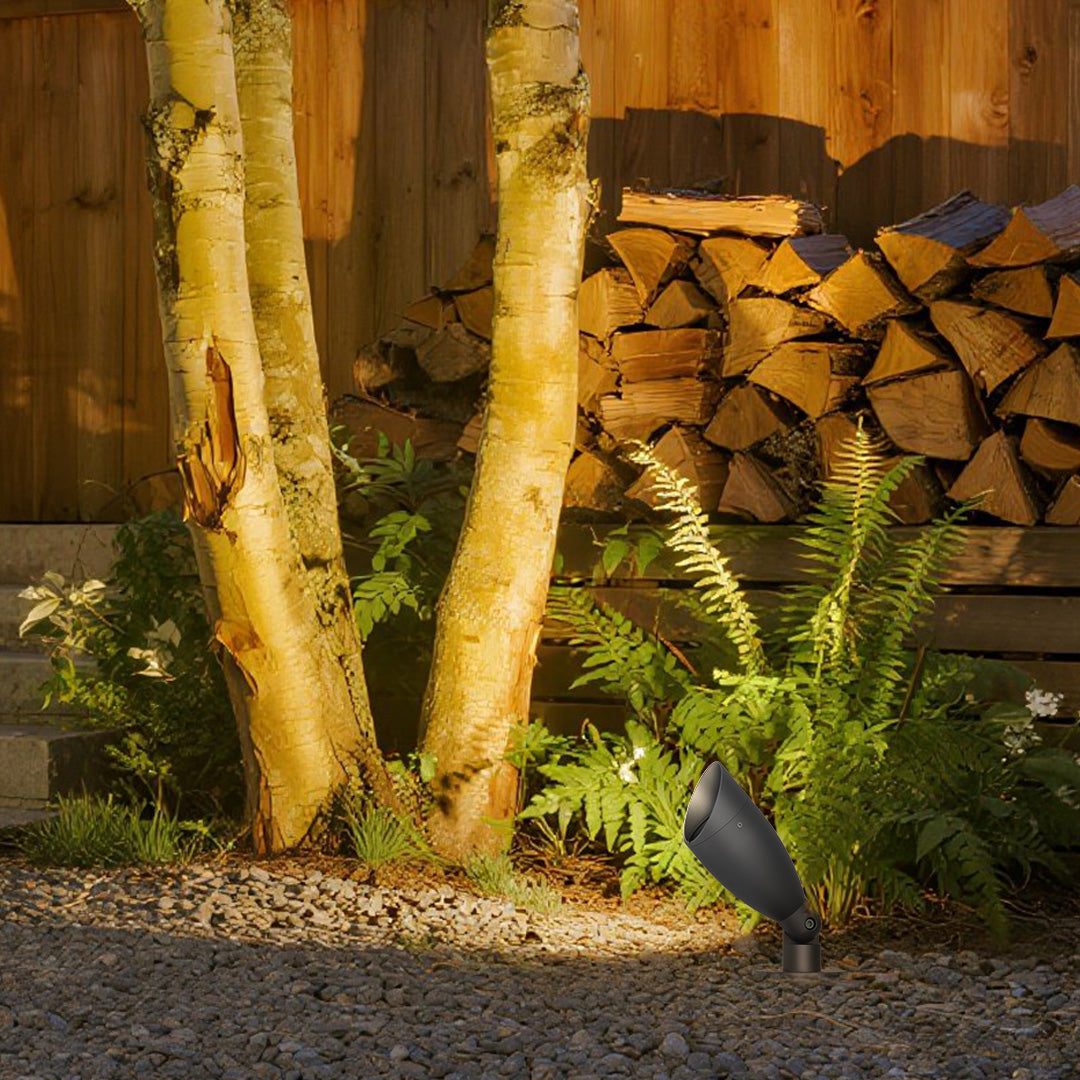 Warm outdoor lighting creating cozy ambiance around wooden deck area with stacked firewood backdrop