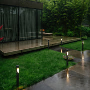 Warm white garden bollard led lights placed beside outdoor seating, creating a cozy landscape ambiance.