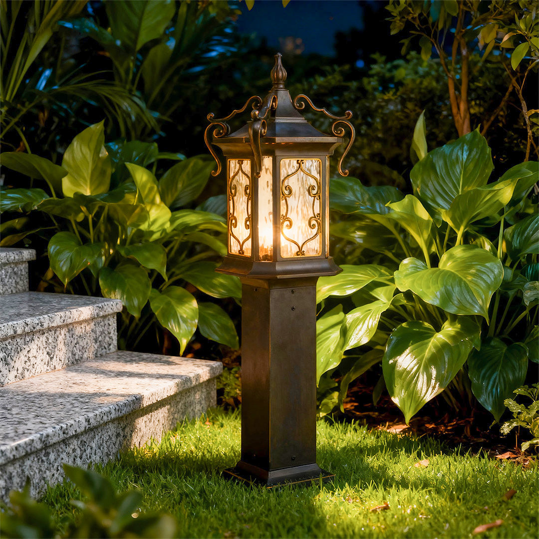 Warm-glow landscape post lights surrounded by plants, perfect for stylish outdoor landscapes.