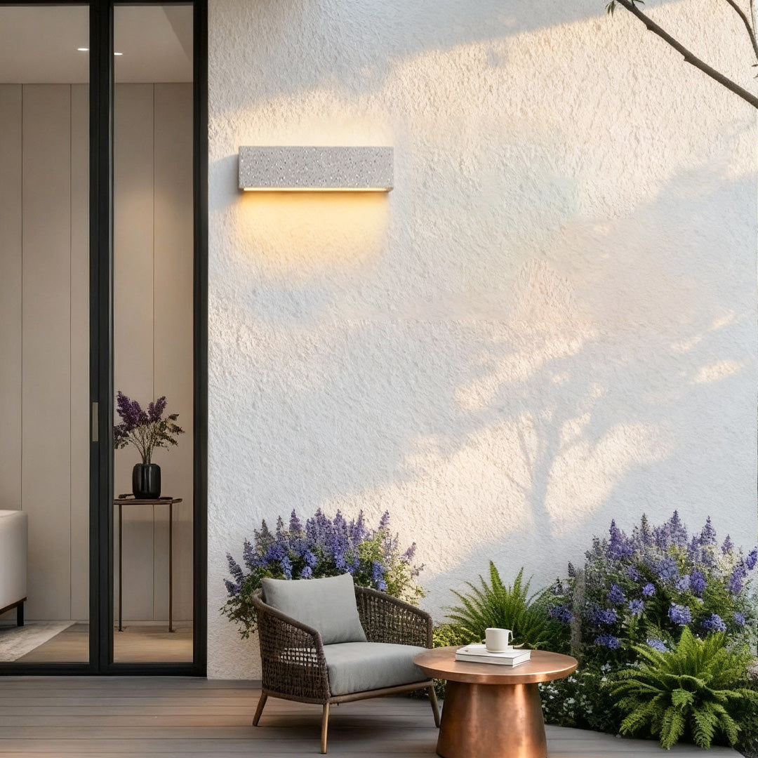 Warm-glow modern outdoor wall sconces mounted on a textured exterior wall creating a soft ambient effect.