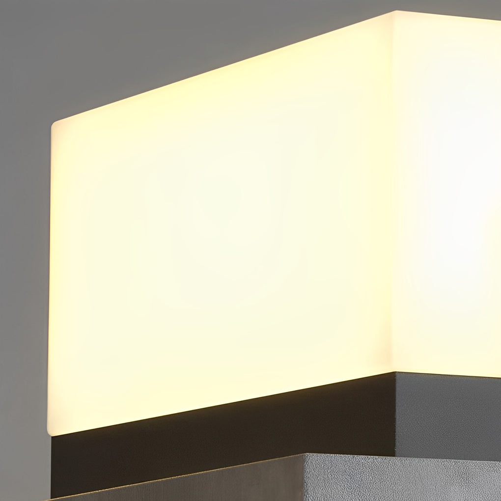 Warm glow solar lawn light highlighting modern outdoor wall and greenery.