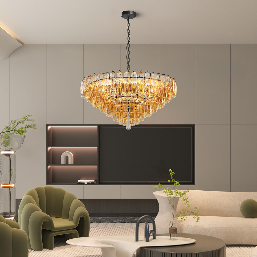 Warm gold glass pendant chandelier hanging above a gray sofa in a stylish living space.