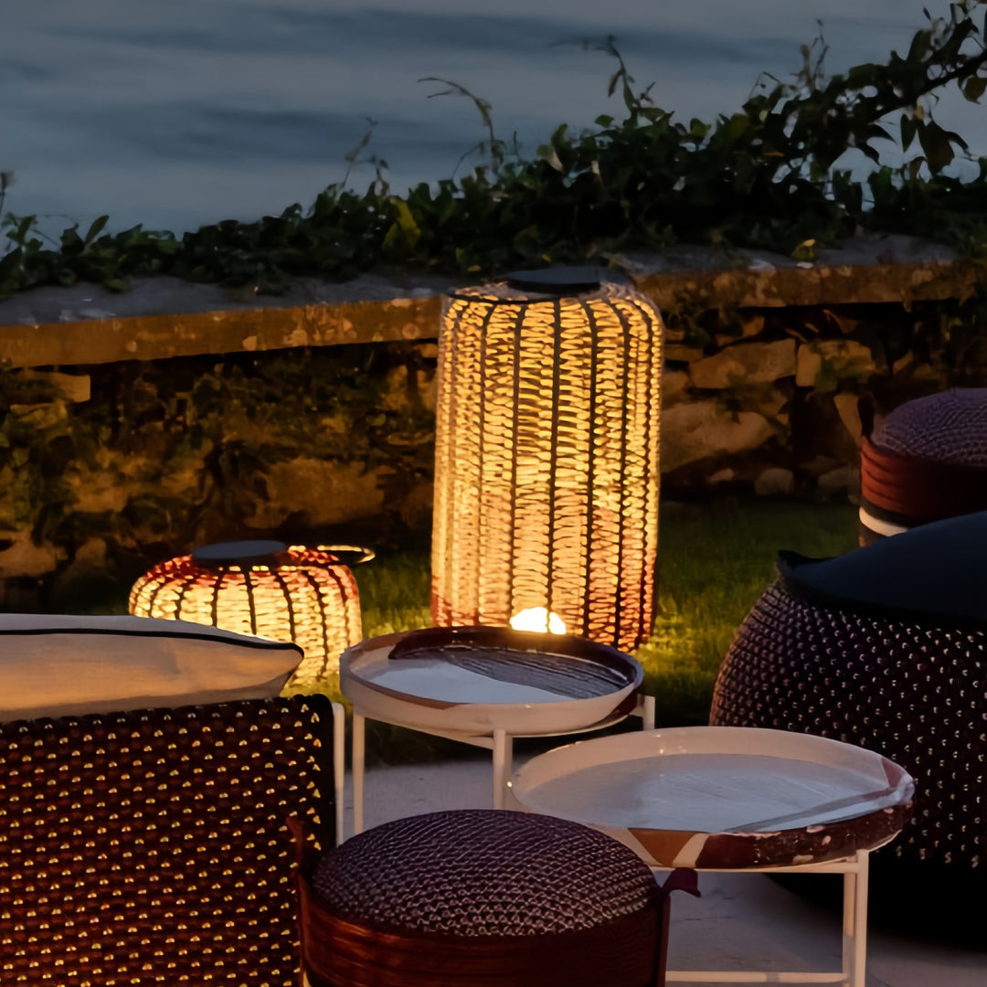 Outdoor LED lantern lights providing a warm, inviting glow on a stone wall patio at night, surrounded by dark outdoor seating.