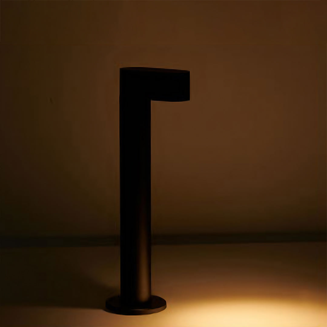 Warm LED path light creating cozy illumination against wooden fence in residential outdoor setting