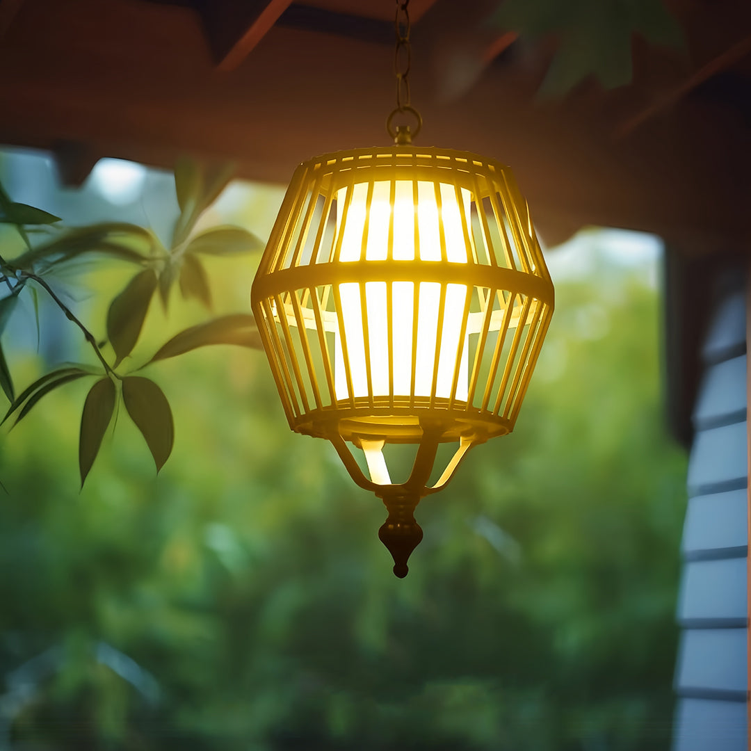 Warm-toned japanese lantern pendant light hanging among lush green foliage, enhancing the tropical garden ambiance.
