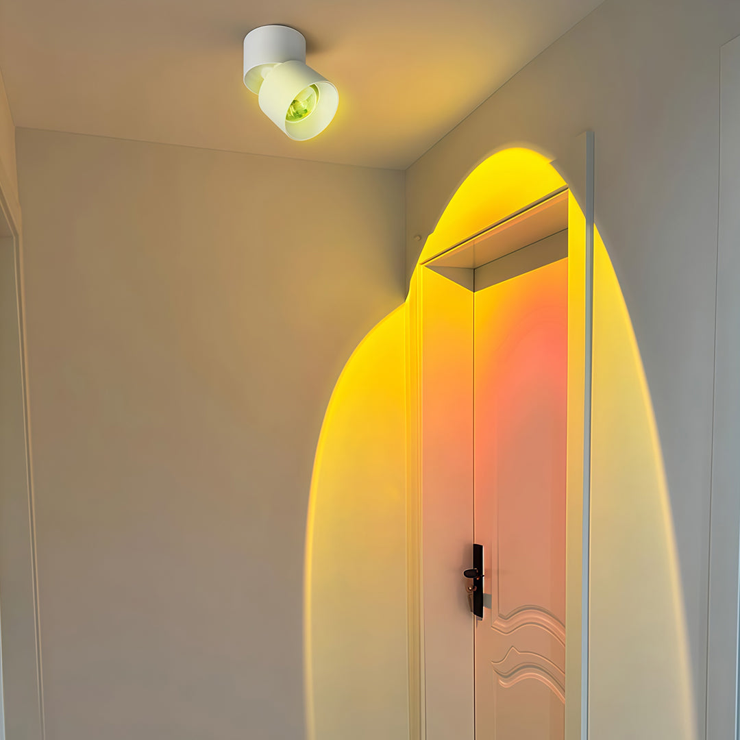 Warm-toned LED ceiling spotlights in black housing with glass shade chandelier design producing soft golden directional beam.