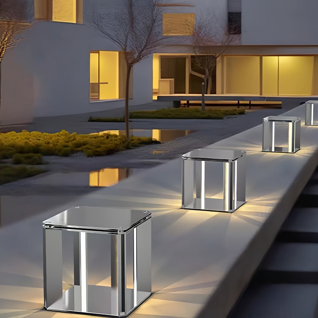 Warm-toned contemporary main gate pillar light design lining outdoor pathways near modern buildings.