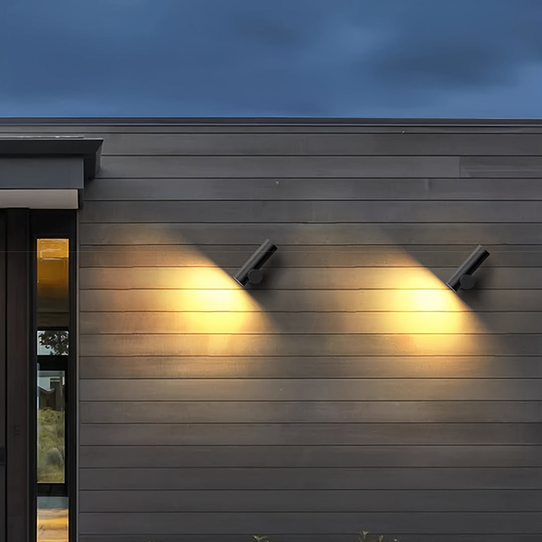 Twin-beam spotlight wall lights illuminating a modern exterior façade with warm directional lighting.