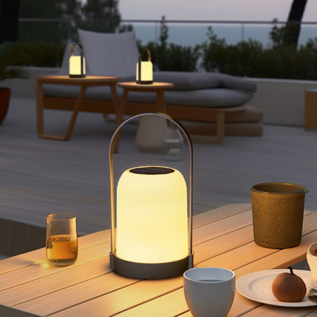 Waterproof LED lanterns providing cozy illumination on wooden outdoor dining table with beverages