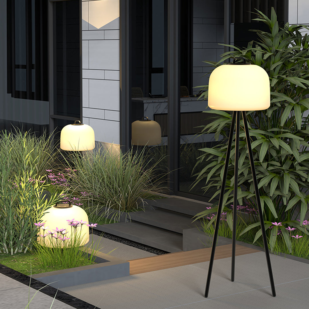 Garden pathway lit by waterproof outdoor floor lamps arranged near plants and steps.